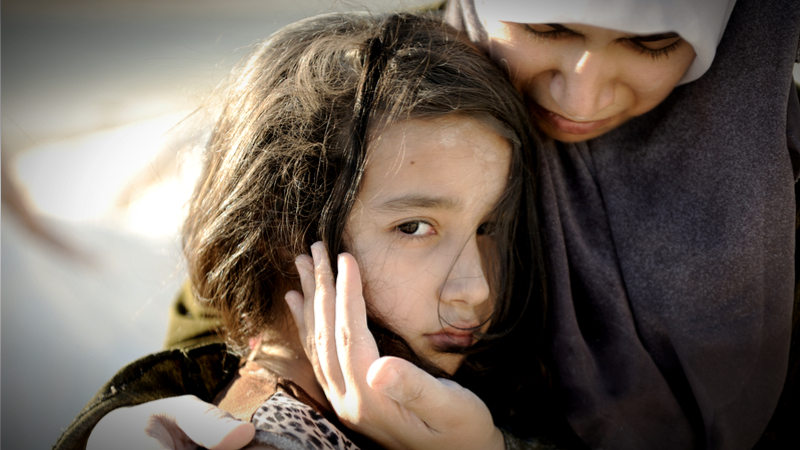 难民妇女抱着悲伤的女孩